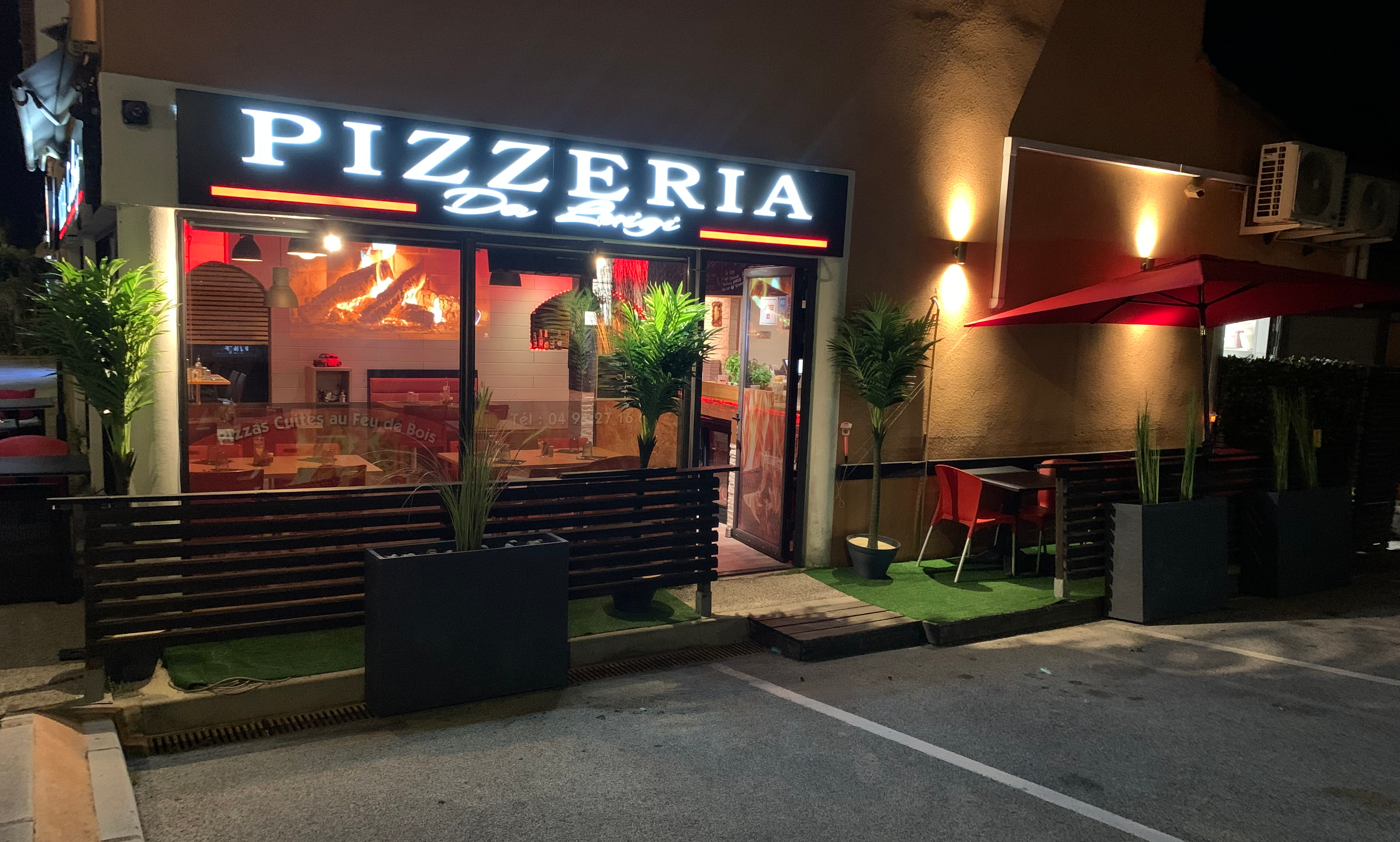 Façade de nuit de Pizza Da Luigi, enseigne néon et terrasse éclairée